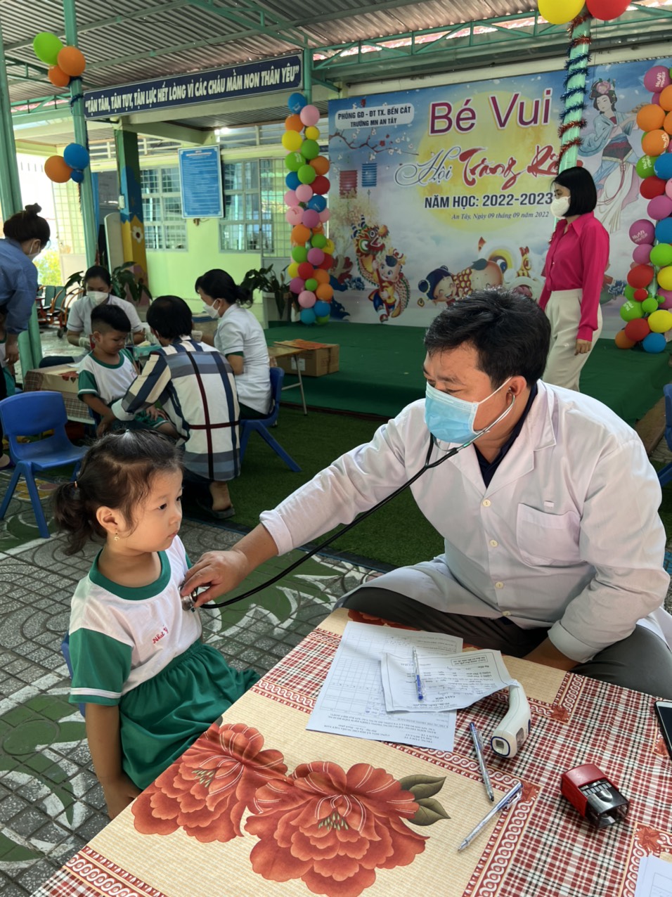 các bé được bác sĩ khám trước khi tiêm ngừa